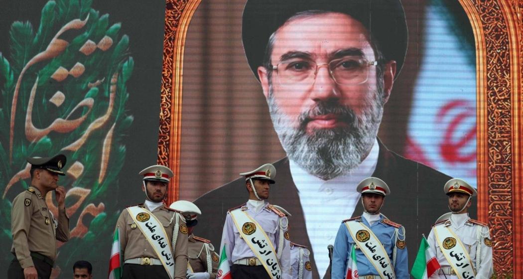 Iranian army soldiers stand in front of a picture of Iran's supreme leader Ayatollah Mojtaba Khamenei during a rally in Tehran on Wednesday. (Image credit: AFP-JIJI)