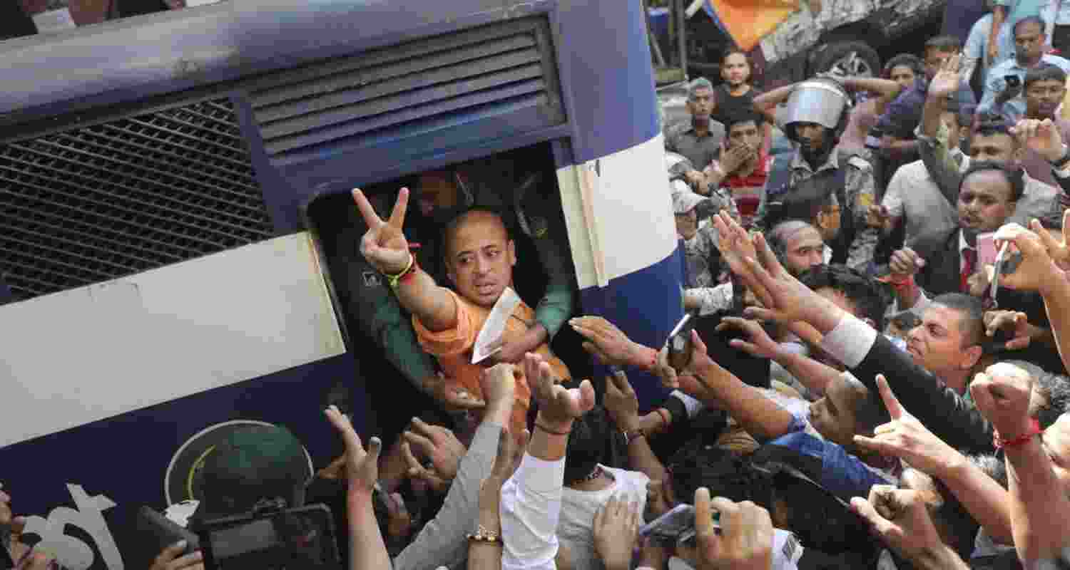 Bangladeshi Hindu leader Krishna Das Prabhu shows a victory sign as he is taken in a police van after court ordered him detained pending further proceedings in Chattogram in Bangladesh.