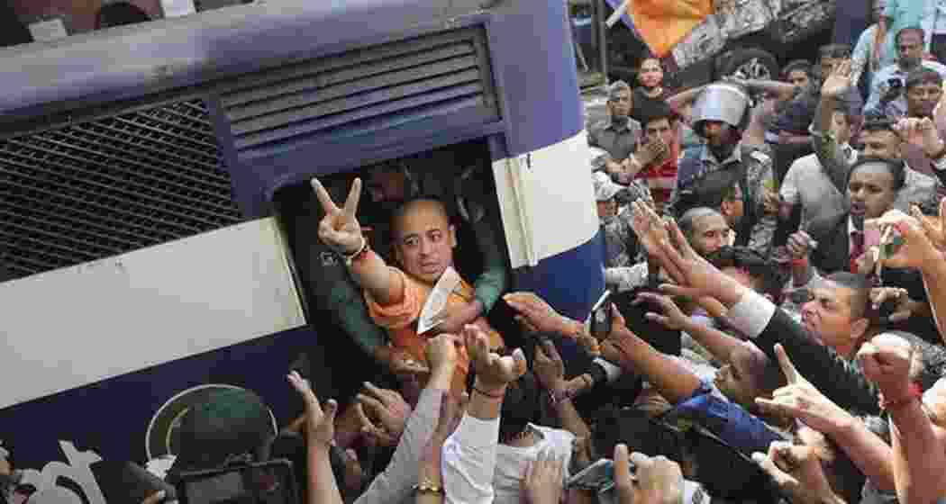Hindu monk Chinmoy Krishna Das Prabhu shows a victory sign as he is taken in a police van in Chittagong, Bangladesh on November 26. 2024.