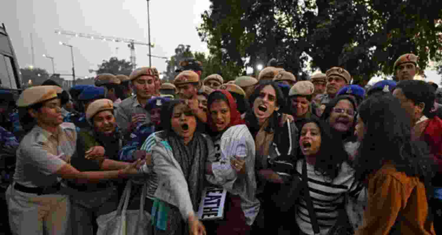 Police personnel detain demonstrators during a protest demanding the government take action to reduce air pollution near India Gate in New Delhi.