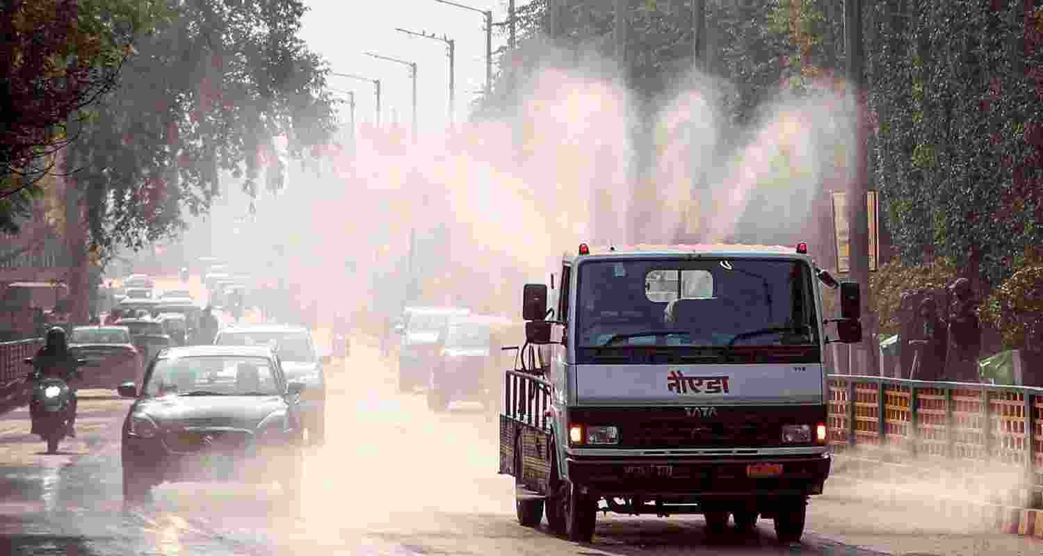A vehicle sprays water in Noida. GRAP-IV measures have been implemented across the Delhi-NCR region.