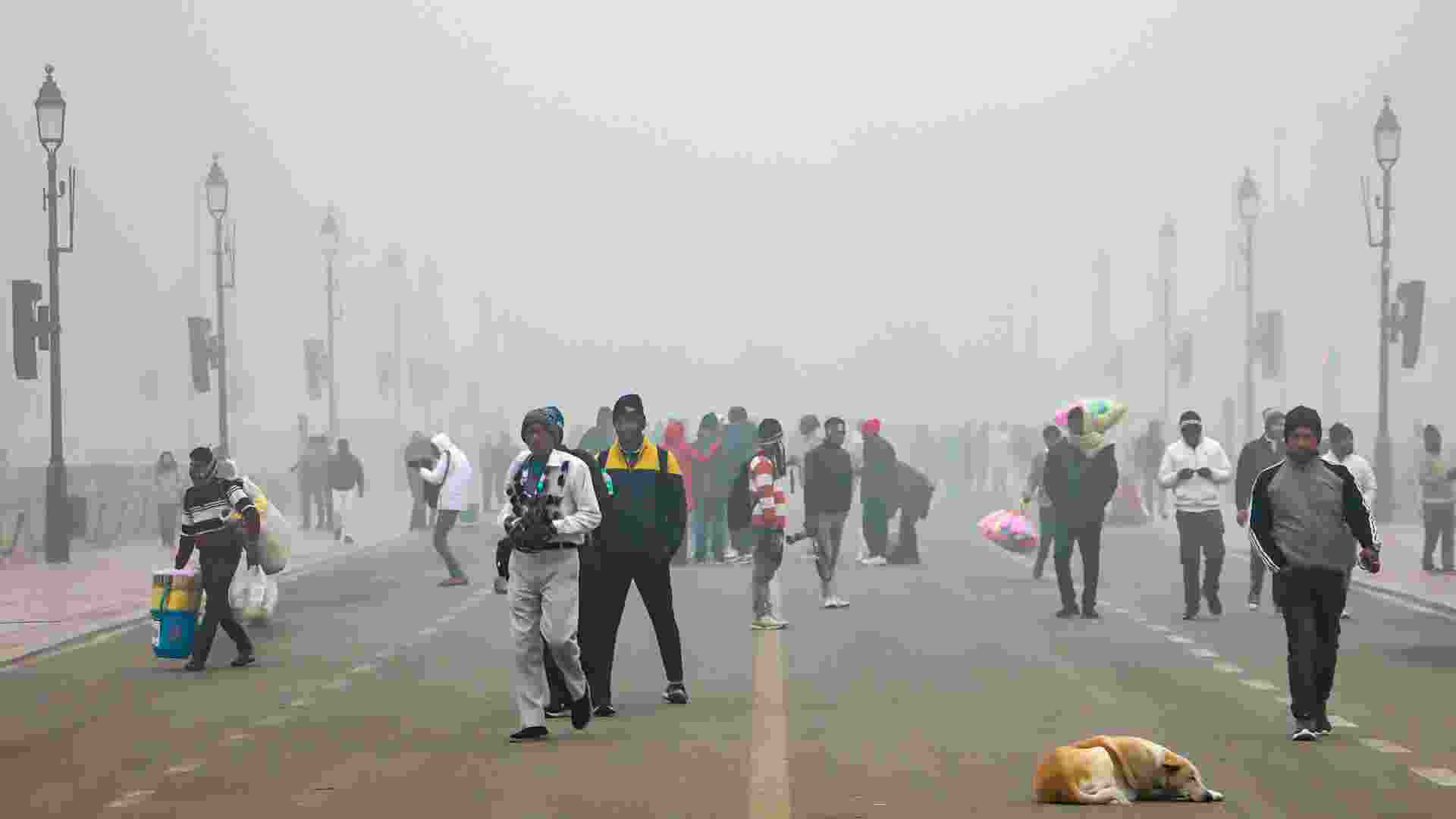 People take a stroll along Kartavya Path on a smoggy winter morning, in New Delhi.