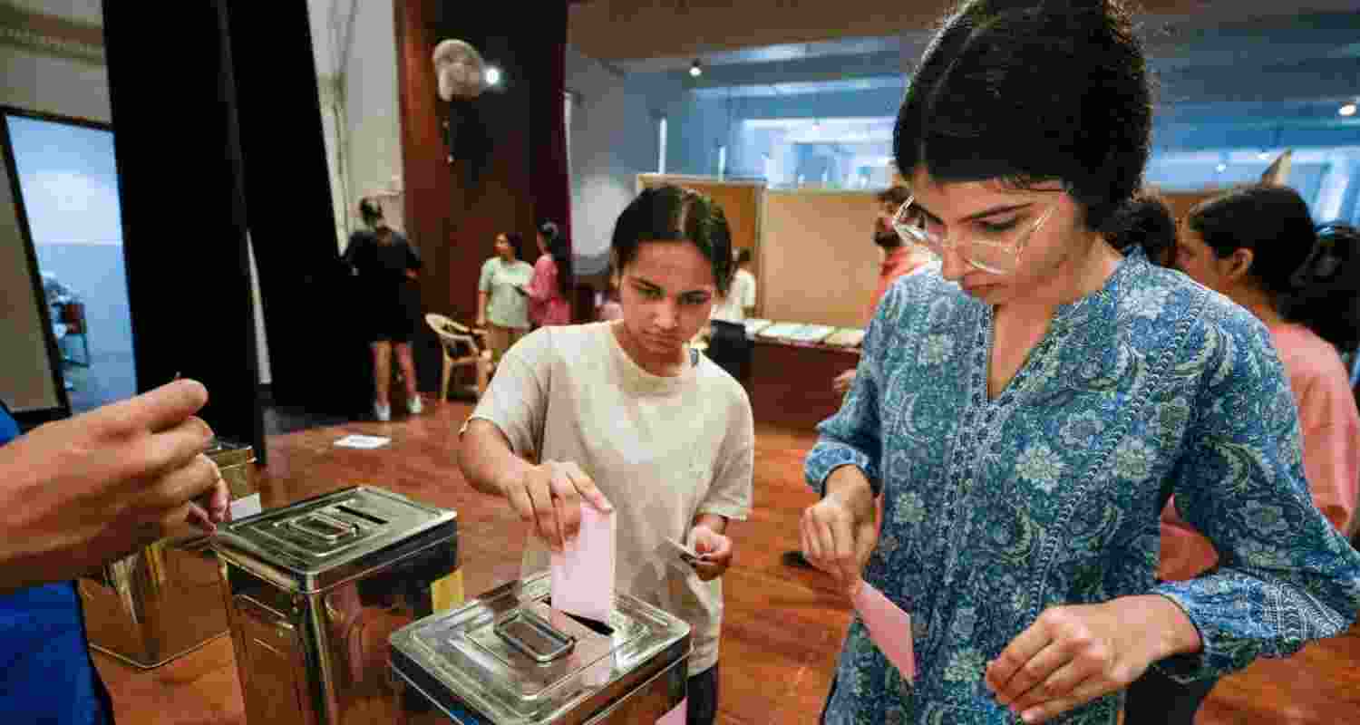 Students cast their votes during the Delhi University Students' Union (DUSU) polls 2024, at Miranda House college, in New Delhi, Friday.