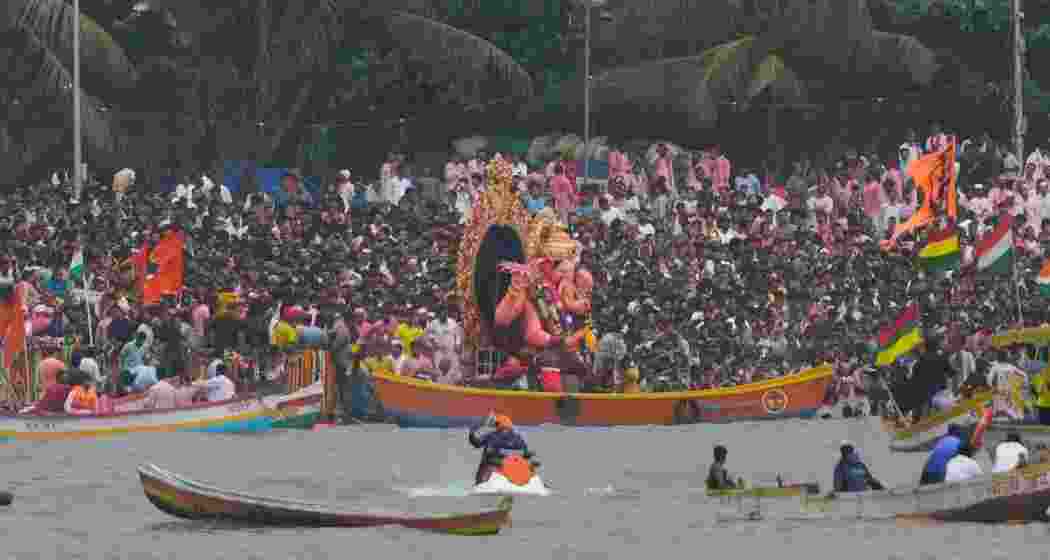 People on boats take part in procession of Lalbaugcha Raja idol of Lord Ganesha before visarjan, immersion, during the 'Ganesh Chaturthi' festival, at Girgaum Chowpatty, in Mumbai, Sunday.