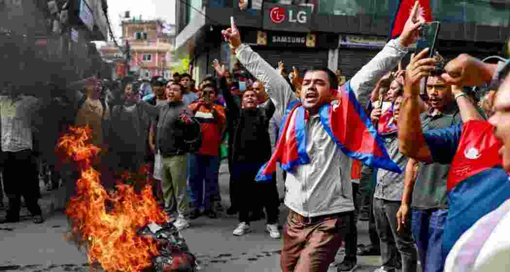 People displaying Nepal’s national flag burn tyres during a demonstration to condemn the police’s deadly crackdown on protesters in Kathmandu on September 9.