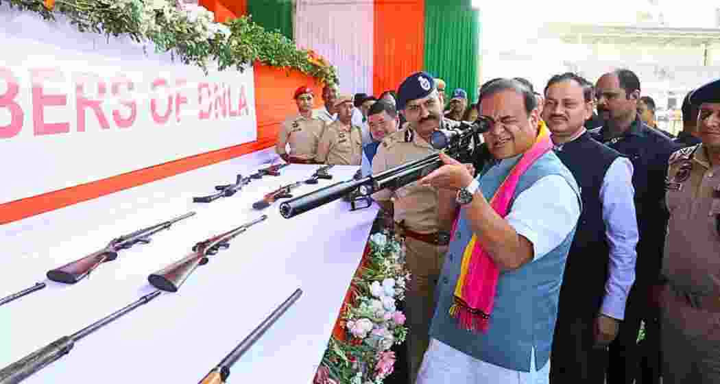 File photo of Himanta Biswa Sarma inspecting a firearm alongside police officials during an official event. File photo of Himanta Biswa Sarma inspecting a firearm alongside police officials during an official event.