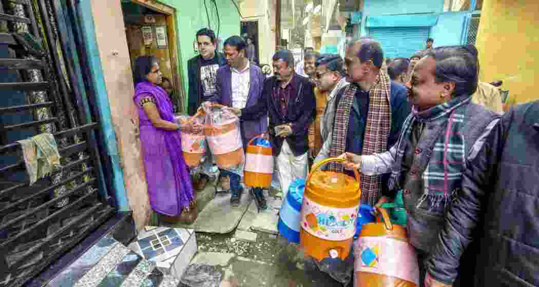Members of social organisations distribute drinking water containers to residents of Bhagirathpura following contaminated water crisis, in Indore on Saturday. 