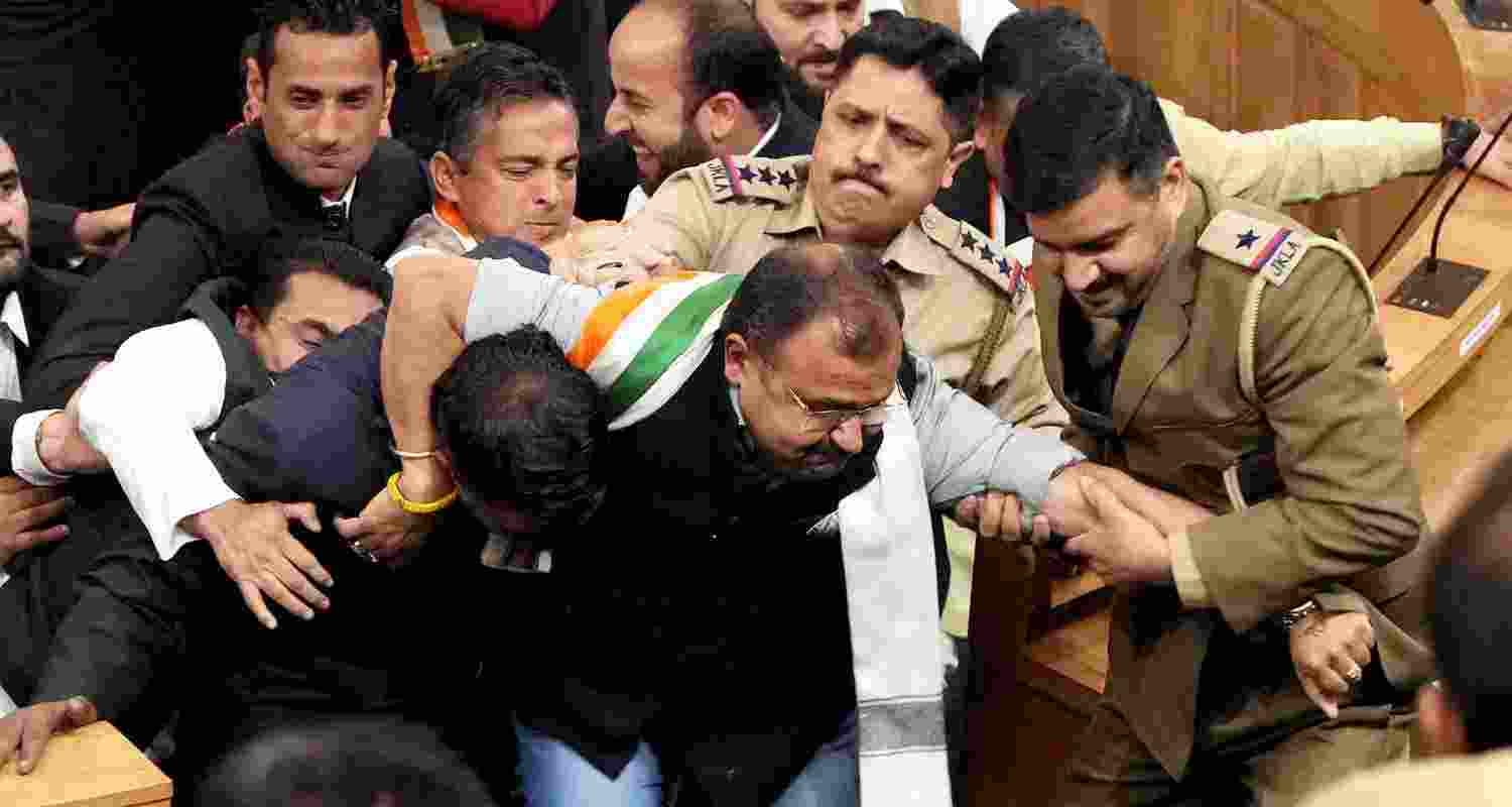 Opposition legislators being marshalled out during a ruckus after BJP members protested over the special status resolution in J-K Assembly, in Srinagar, Friday, Nov. 8, 2024.