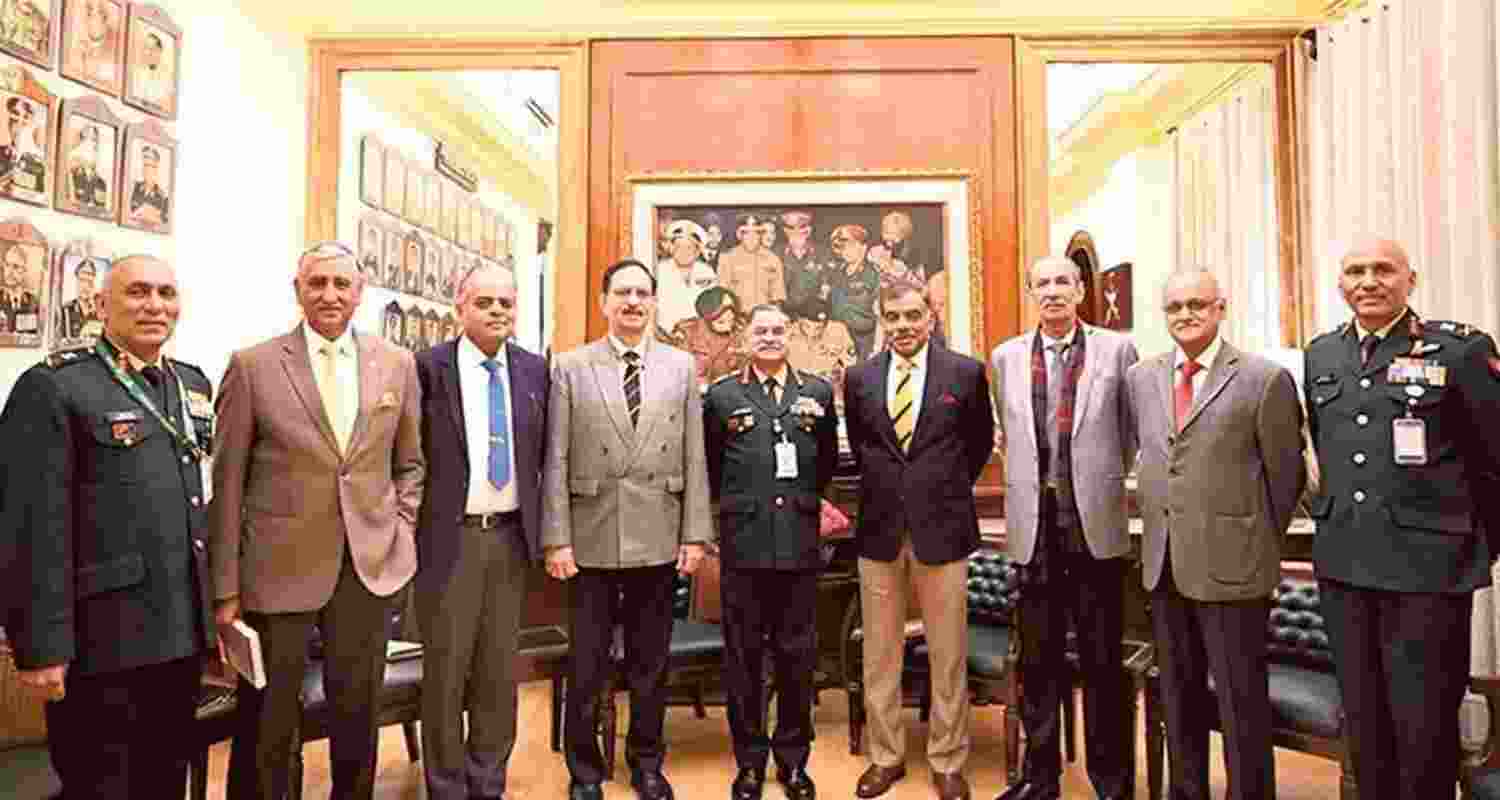 Officials are seen standing before the painting showing Pakistan’s surrender during the 1971 Bangladesh war.