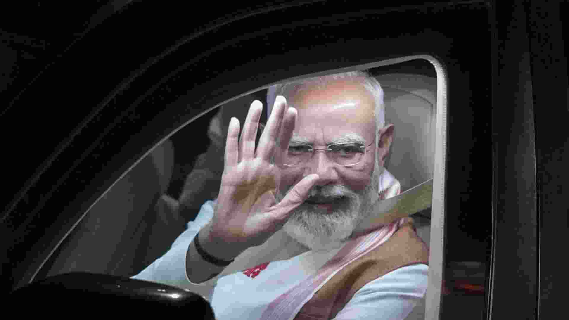 Prime Minister Narendra Modi waves during the roadshow, in Guwahati on Saturday. 
