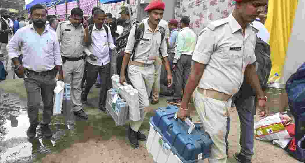 Security personnel with Electronic Voting Machine (EVM) and other election material leave for polling duty. (Image: PTI)