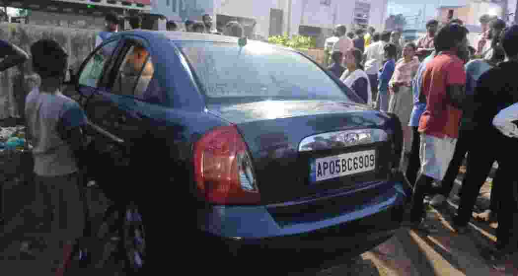 Locals at the scene where four children tragically died after being locked inside a stationary car in Vizianagaram, Andhra Pradesh, on Sunday.