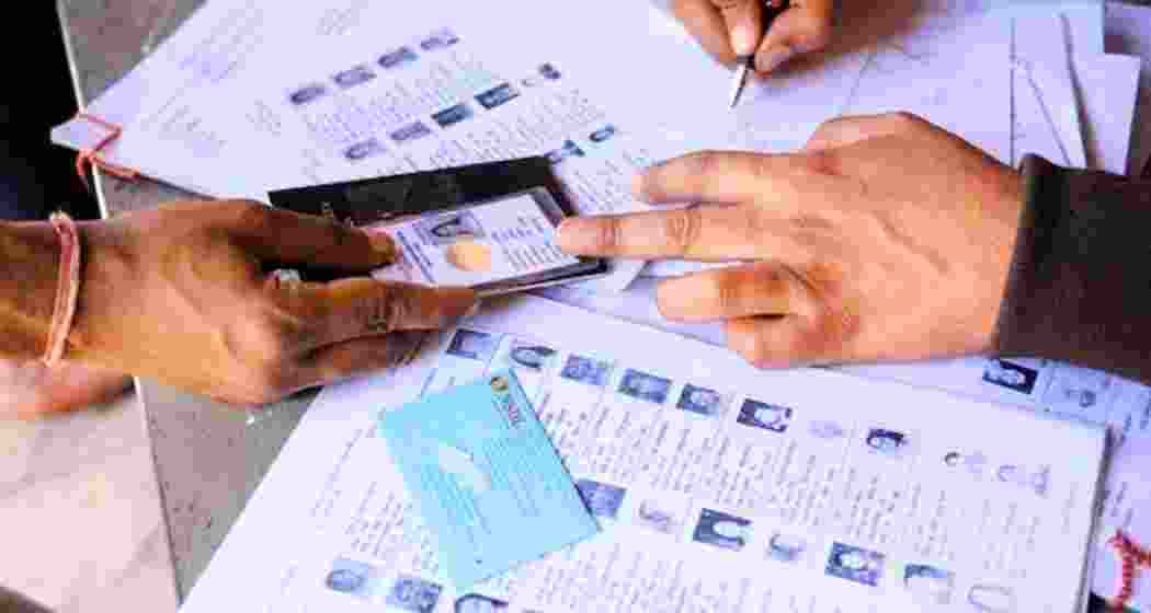 Election Commission staff display draft electoral rolls at a booth in Bihar as part of the SIR process.