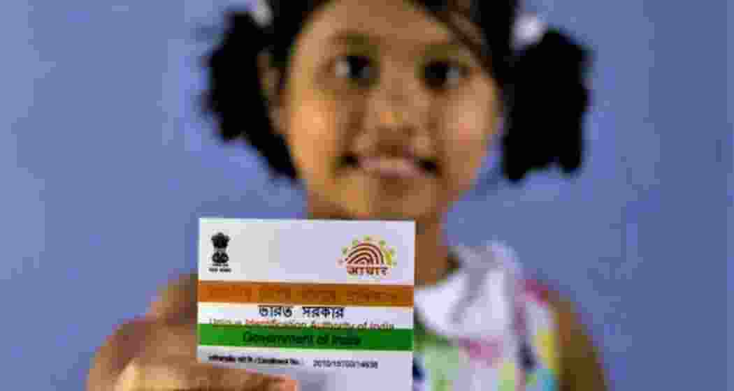 A child holding an Aadhaar card. 