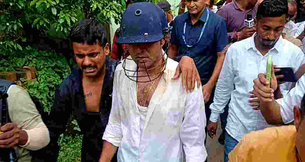 TMC national general secretary and MP Abhishek Banerjee, wearing a protective helmet, is escorted by security personnel and party workers after coming under attack from protesters during a visit to families of alleged post-poll violence victims in Sonarpur, South 24 Parganas, on Saturday.