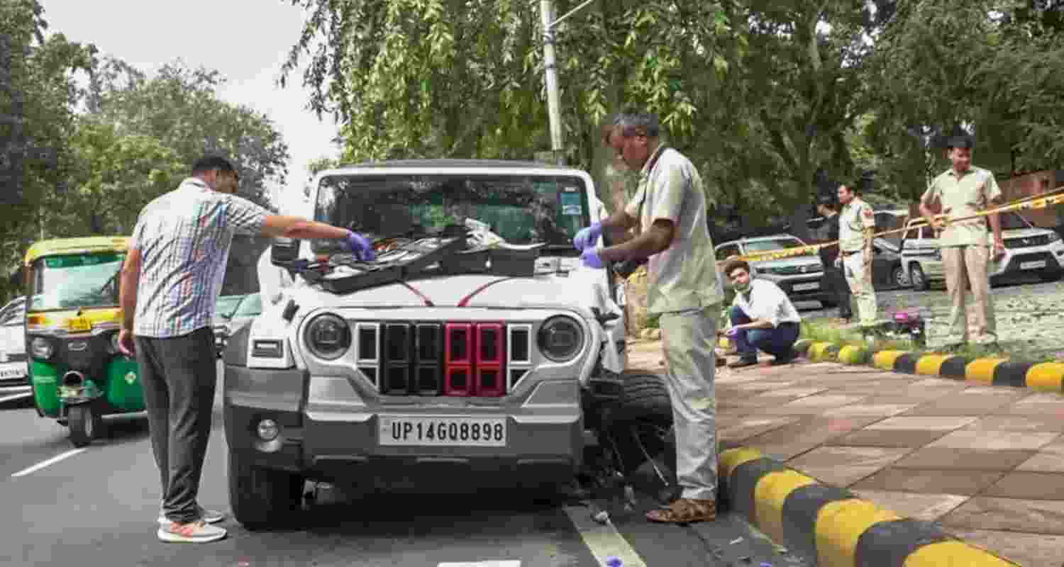 Police personnel and forensic experts at the site after a speeding white Thar kills one person, injures another at Mother Teresa Road, in New Delhi.