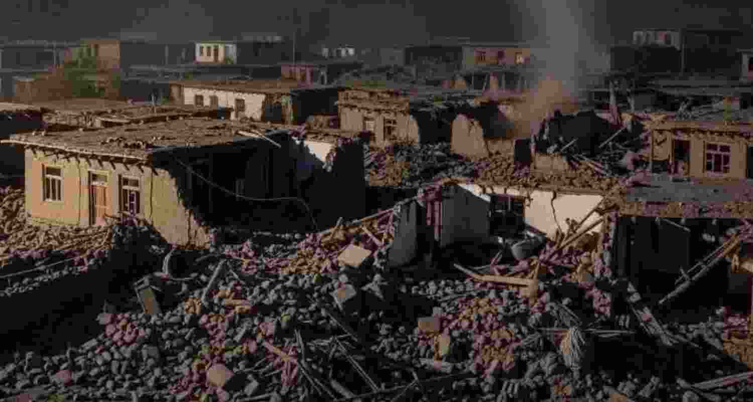 Taliban soldiers and civilians carry earthquake victims to an ambulance at an airport in Jalalabad, Afghanistan.