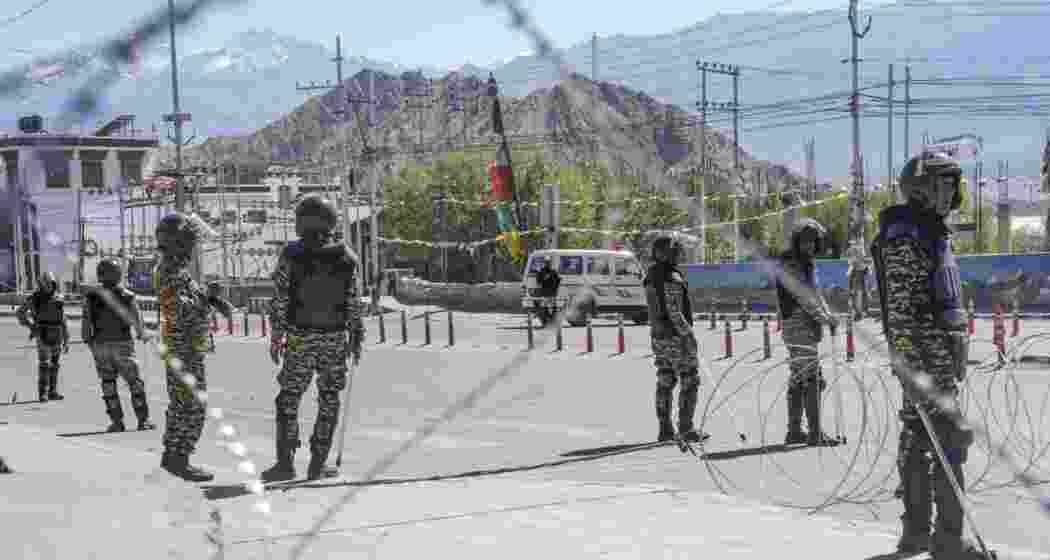 Security personnel stand guard on a road amid curfew. (Image: PTI)