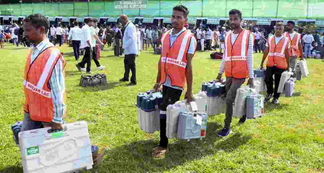 Polling officials collect EVMs, VVPATs and other election materials from a distribution centre on the eve of Assam Assembly Election, in Nagaon district, on Wednesday.
