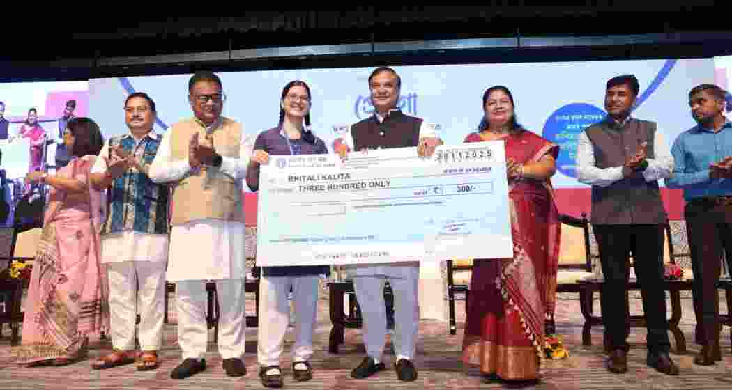 Assam Chief Minister Himanta Biswa Sarma presents a cheque to a schoolgirl during the launch of the Prerona scheme in Guwahati on Friday.