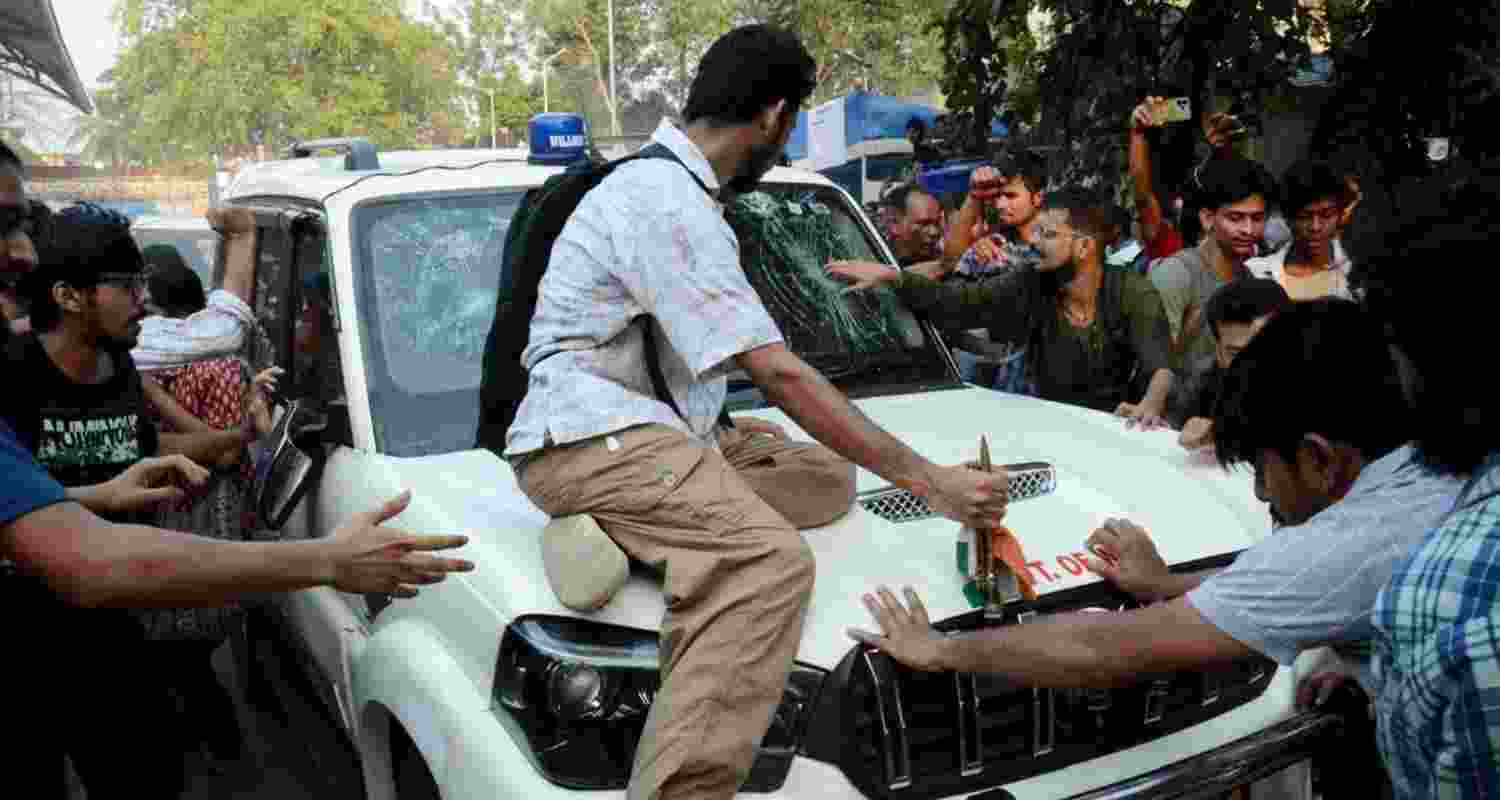 Students’ Federation of India (SFI) members gather around West Bengal Education Minister Bratya Basu’s car at Jadavpur University campus, in Kolkata.