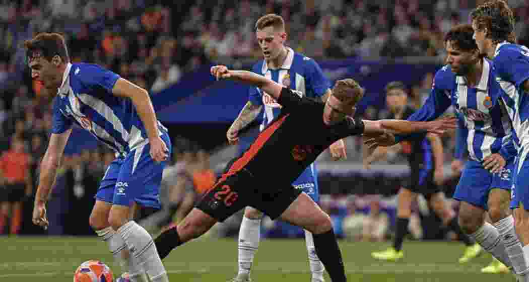 Barcelona's Daniel Olmo (C) contests the ball during the LaLiga match against Espanyol at the RCDE Stadium in Cornella de Llobregat on Thursday, 15 May 2025.