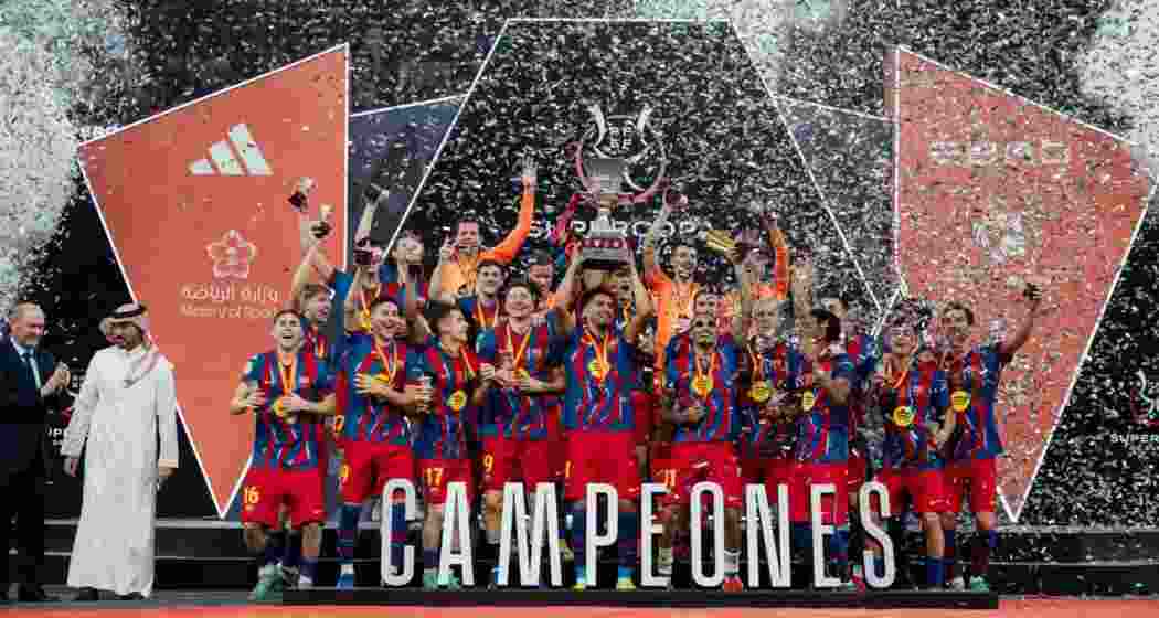 Barcelona players celebrate with the Spanish Super Cup trophy in Jeddah after defeating Real Madrid 3-2.
