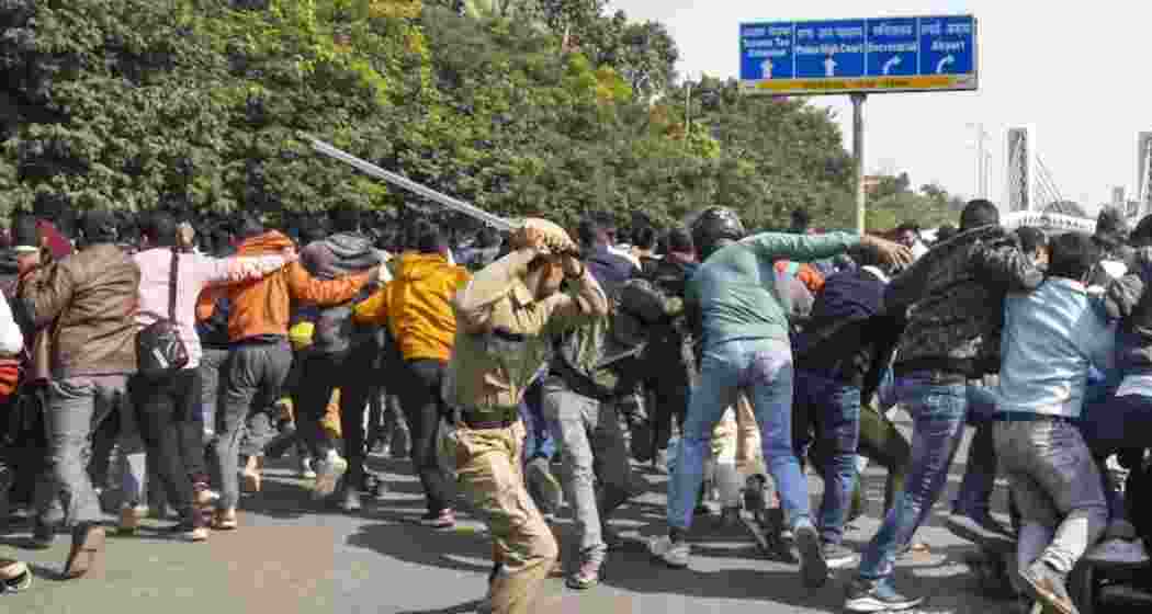 A police official lathicharges aspirants during their protest over normalization of the 70th Bihar Public Service Commission (BPSC) examination, outside BPSC office, in Patna.