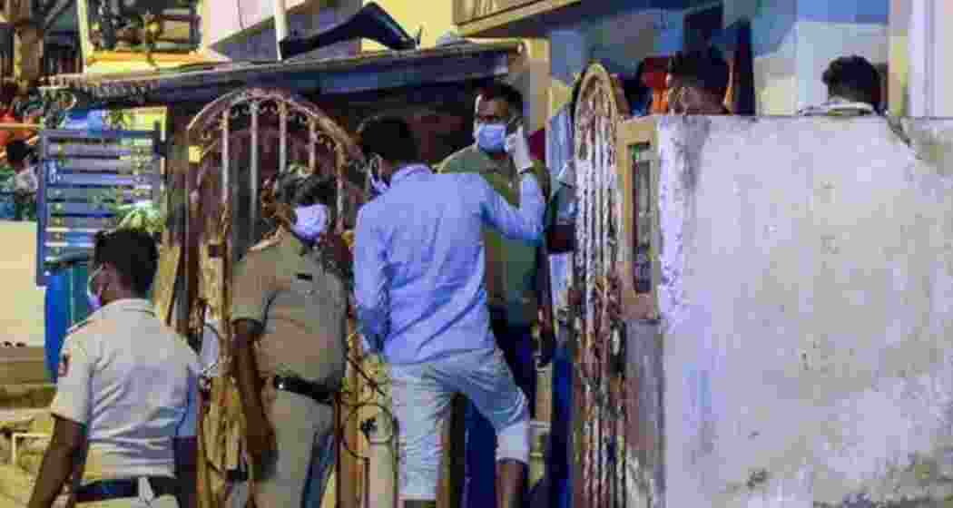 Police personnel investigate after the dead body of a woman, cut into pieces, was found stored in a refrigerator, at Vyalikaval in Bengaluru on Saturday.