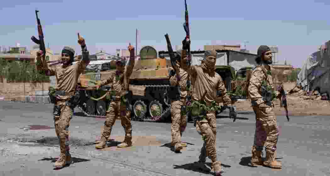 Syrian security forces walk together along a street, after clashes between Syrian government troops and local Druze fighters resumed in the southern Druze city of Sweida early on Wednesday, collapsing a ceasefire announced just hours earlier that aimed to put an end to days of deadly sectarian bloodshed, in Sweida, Syria July 16, 2025.

