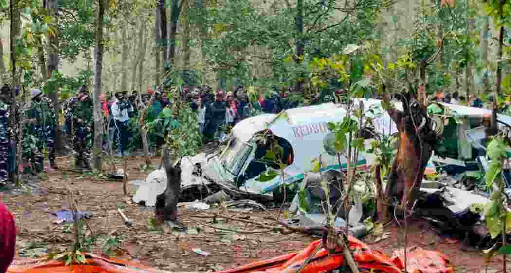 A crowd of onlookers gather at the crash site in Jharkhand's Chatra as security personnel continue search operations around the debris of the Redbird Airways Pvt Ltd Beechcraft C90 air ambulance that crashed on Monday and killed all seven members onboard.