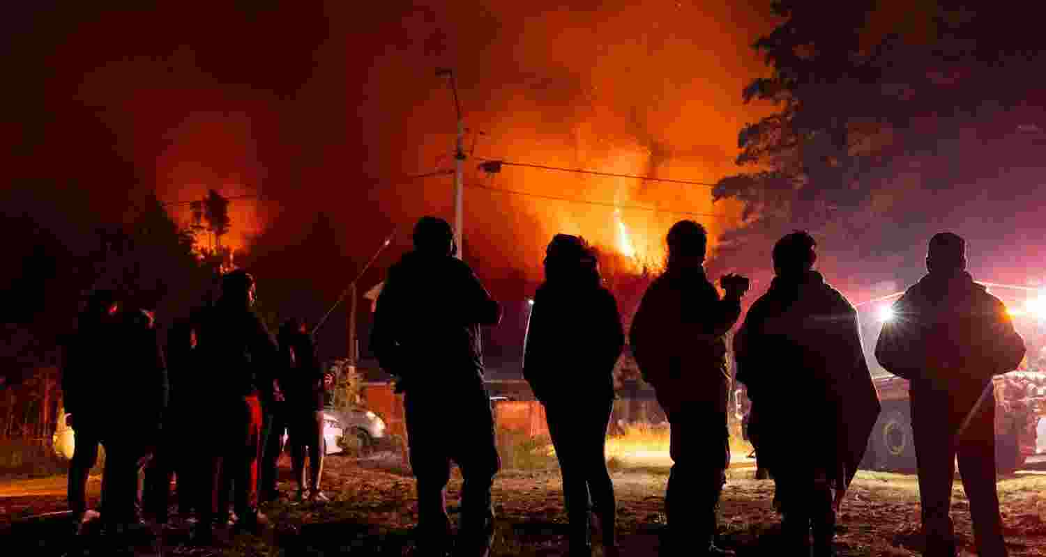 Residents look out at wildfires by their homes near Concepcion, Chile