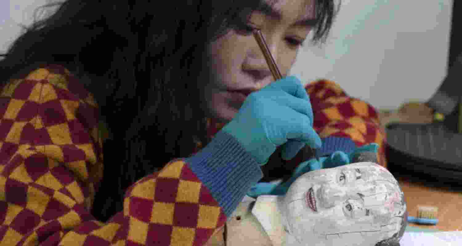 A restorer works on the head of a mechanical doll that manually moves a fan that once kept the imperial family cool on the sprawling compound of the Forbidden City also known as the Palace Museum in Beijing.