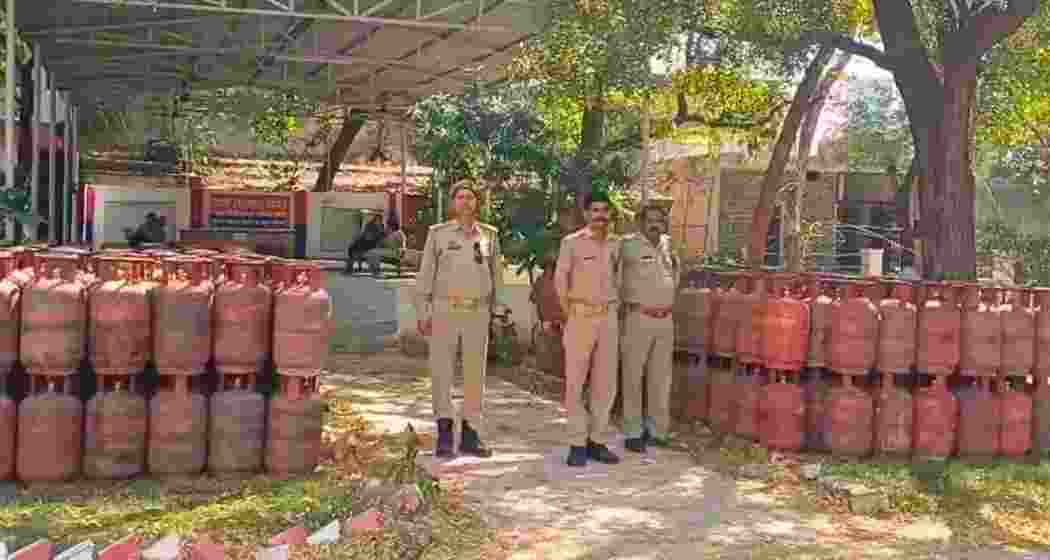 Police personnel stand guard beside the recovered LPG cylinders. 