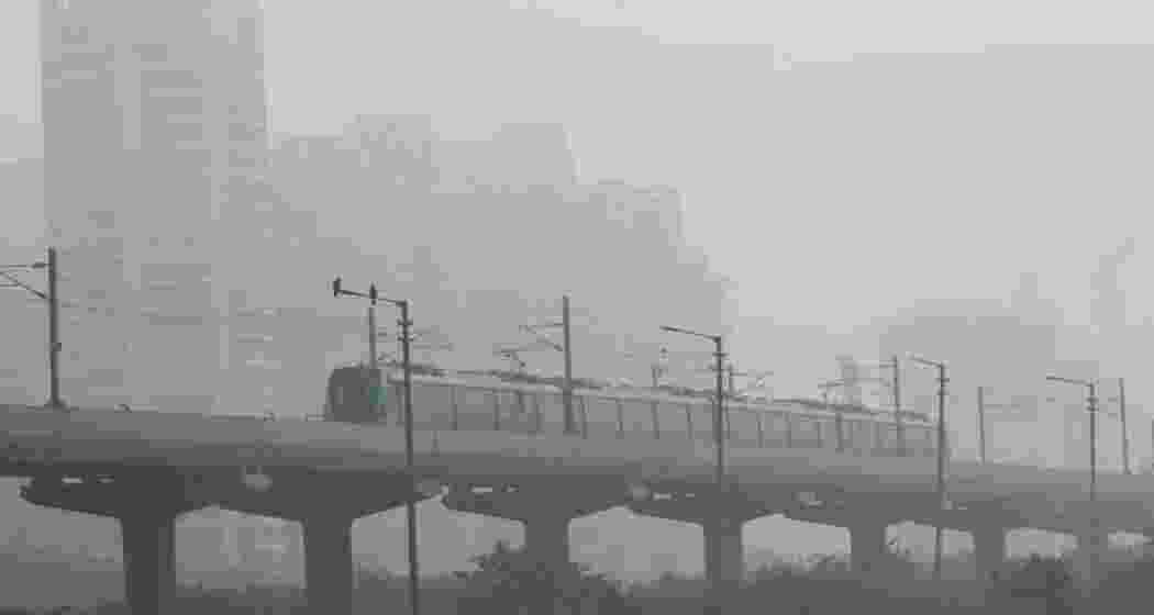 A Delhi Metro train glides through thick fog. The weather conditions have been affecting visibility and transport across the city as cold wave conditions persist in the capital.