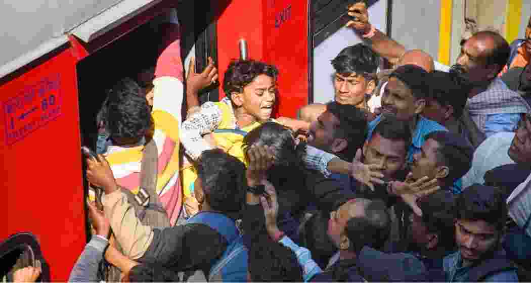 Passengers scramble to board trains at a railway station in Patna, amid heightened crowd control measures following the deadly stampede at New Delhi railway station. 