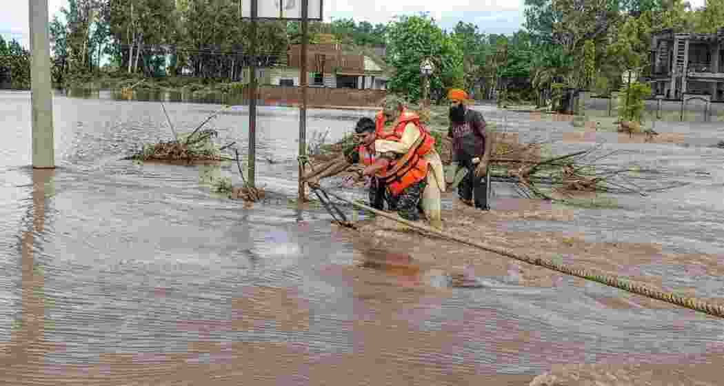An NDRF official rescuing an elderly man in a village of Fazilka district. (File photo)