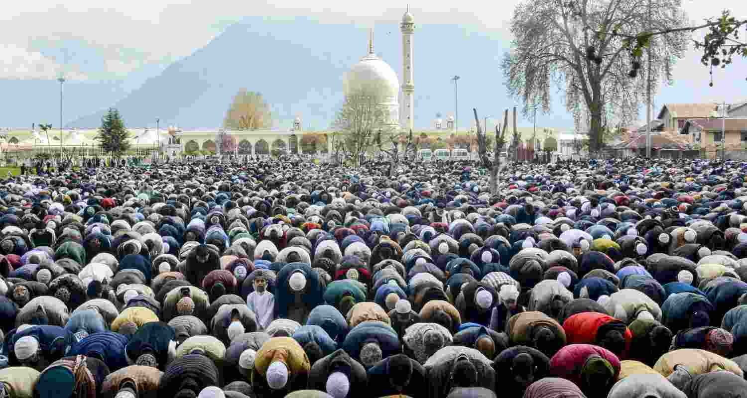 People from the Muslim community offer 'namaz' during the 'Eid al-Fitr' festival, at Dargah Hazratbal Shrine in Srinagar, Saturday. 