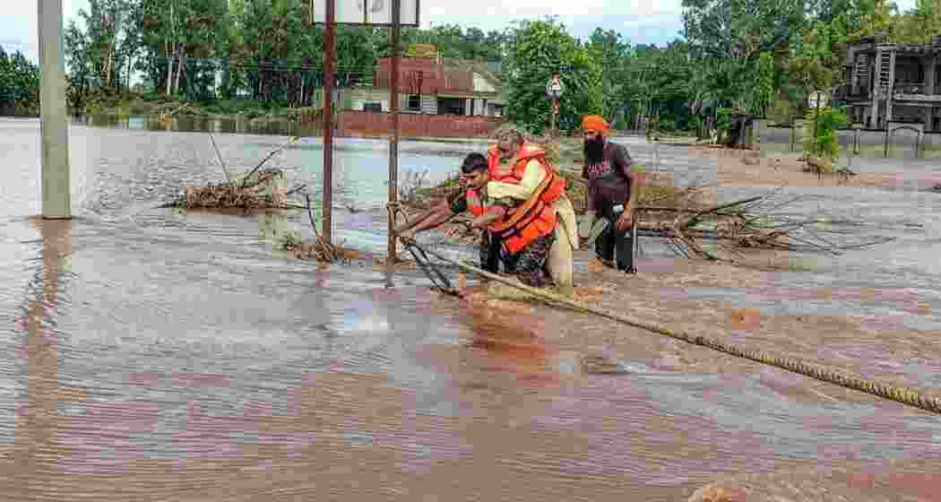 An Army officer carrying a snake bite victim to safety during an evacuation operation in the Ramdass area of Amritsar district.
