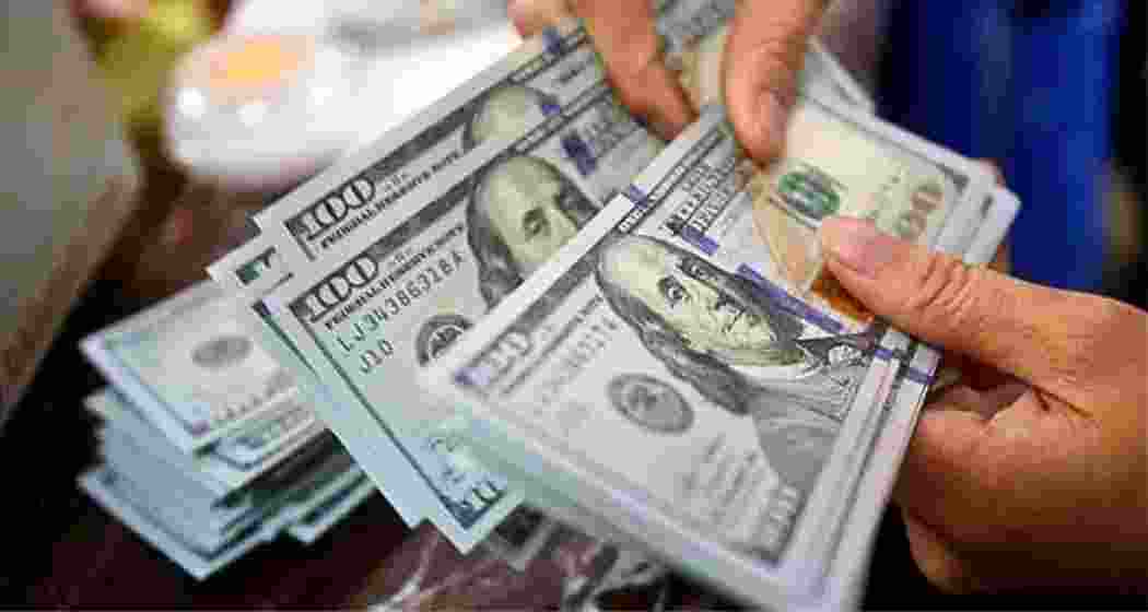 A representative image of US currency being handled. 