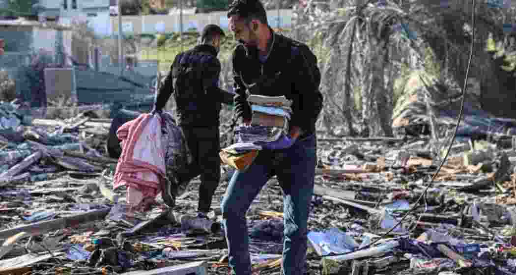 Palestinians search for their belongings amid the rubble of houses destroyed by Israeli bombardment in Rafah in the southern Gaza Strip. .
