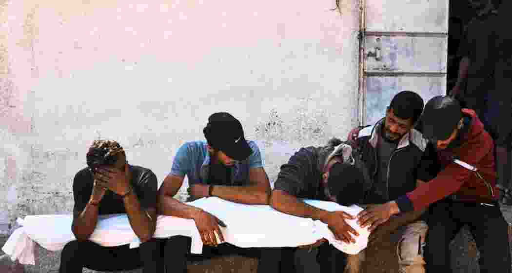 Palestinians mourn over the bodies of their relatives who were killed in an Israeli military strike on Gaza at Al-Shifa Hospital in Gaza City, Wednesday, June 4, 2025.