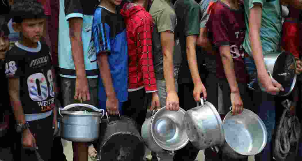 Children wait for food to beat Gaza’s hunger crisis.