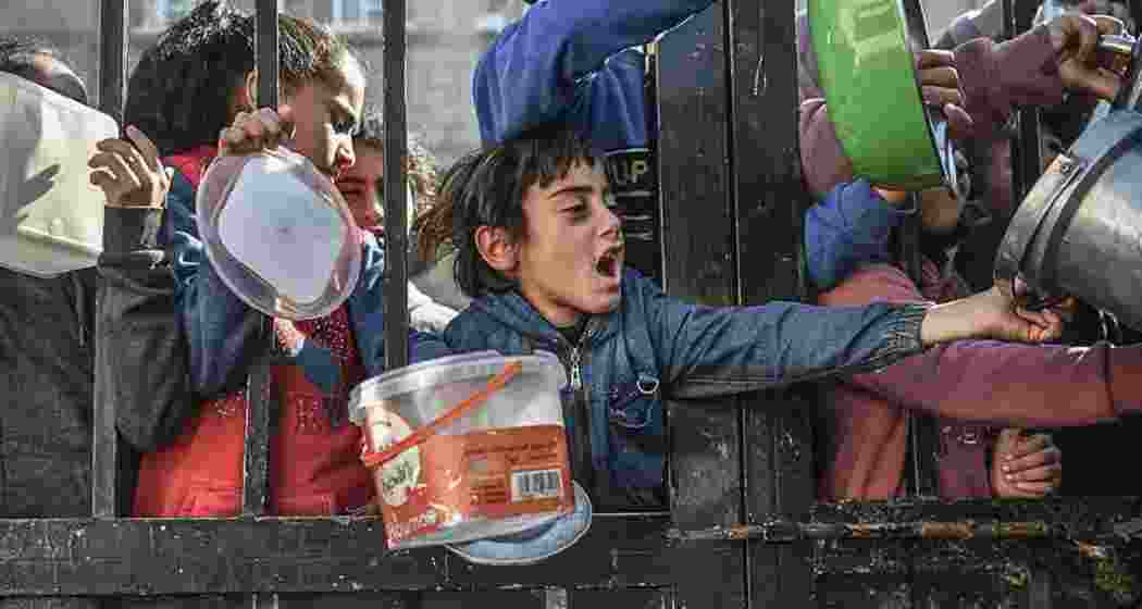 Children wait to receive food in the city of Rafah, southern Gaza.