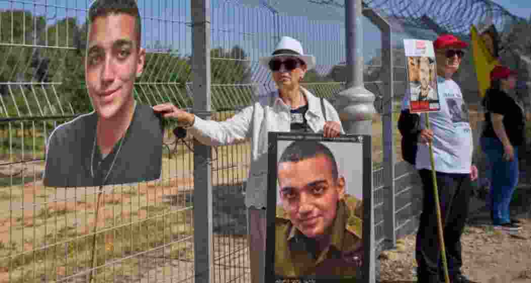 Israeli-American hostage Edan Alexander's grandmother, Varda Ben Baruch, holds photos of her grandson alongside other hostage families during a rally for kins of hostages at Nir Oz, near the Gaza border.r.