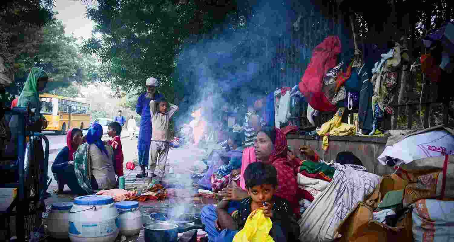 Homeless people set up temporary lodgings on a street in New Delhi.