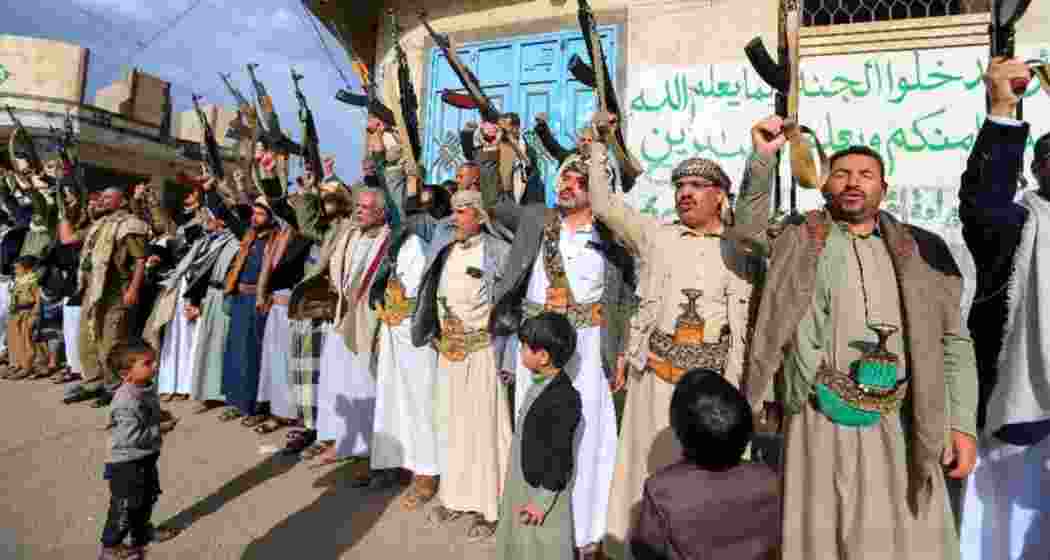 Houthi militants brandish their weapons in a show of defiance, vowing retaliation against US airstrikes in Yemen, as tensions escalate in the Red Sea following deadly attacks.