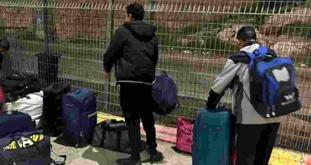 Indian construction workers stand in a queue during legal procedures at the Israel-Palestine border after being rescued by Israeli authorities.