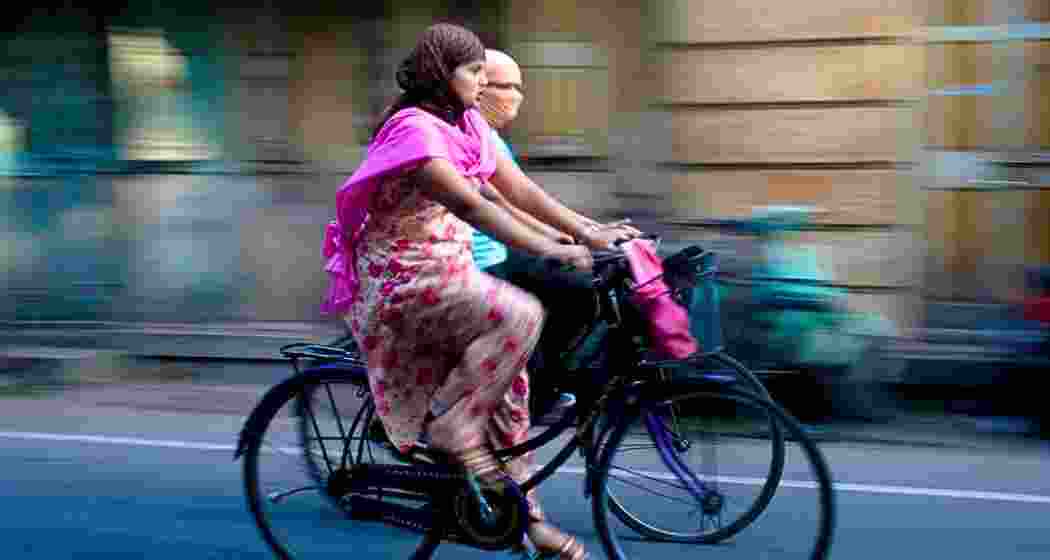 Two women ride bicycles in Jaipur, Rajasthan. 