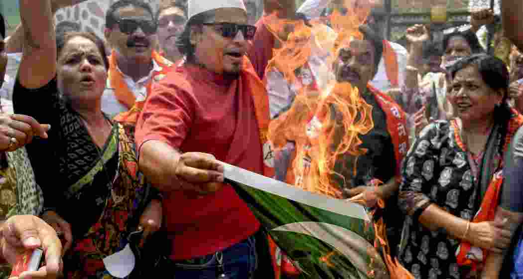 Shiv Sena activists burn a printout depicting the Pakistani flag during a protest against Pahalgam terror attack, in Mumbai, Wednesday, April 23, 2025.